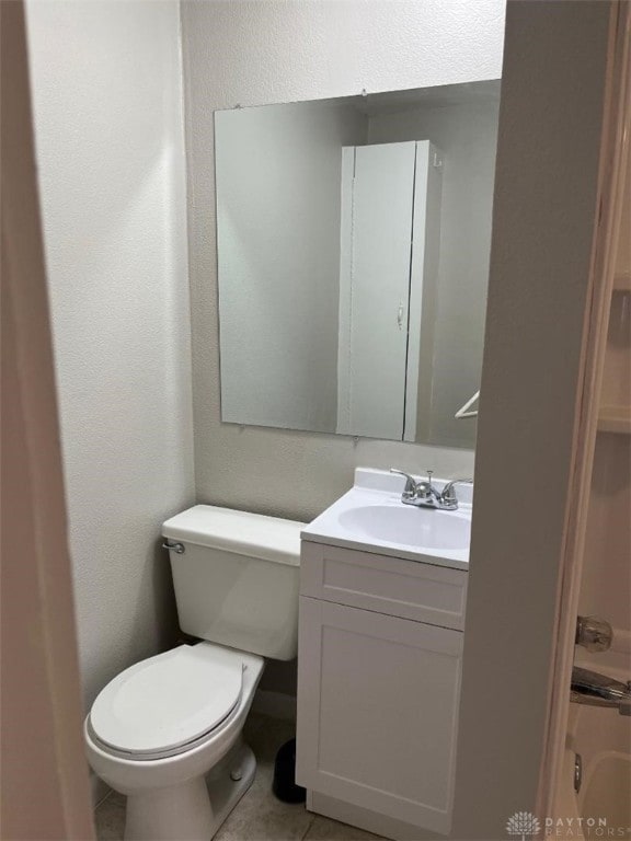 bathroom featuring toilet, tile patterned flooring, and vanity