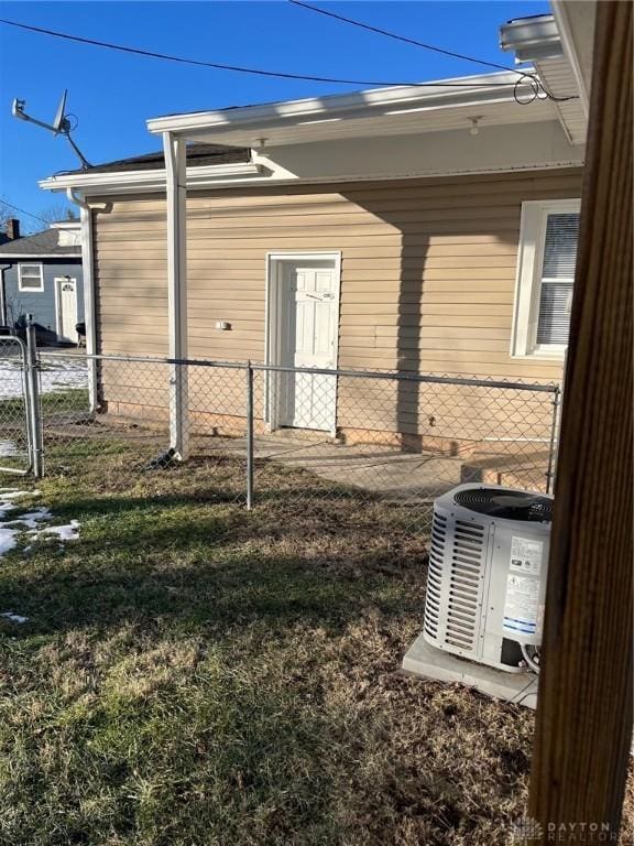 view of side of home featuring central AC unit and fence