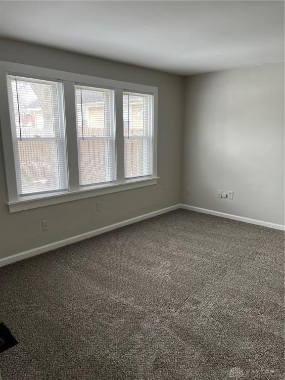 carpeted empty room with baseboards and a healthy amount of sunlight