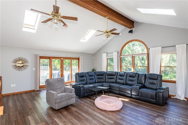 living room with plenty of natural light, a skylight, wood finished floors, and beam ceiling