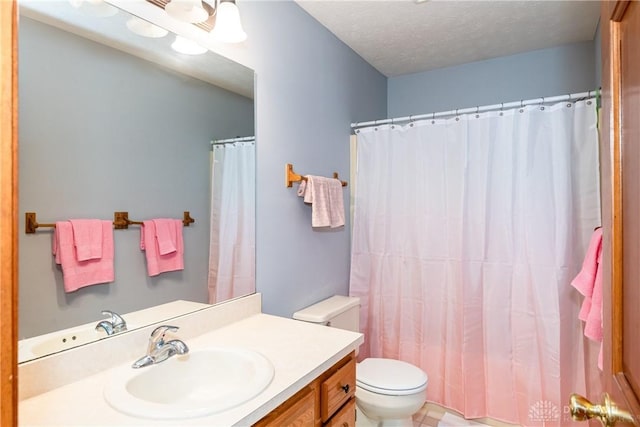 bathroom with a textured ceiling, curtained shower, vanity, and toilet