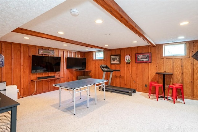 game room featuring carpet floors, beam ceiling, and wooden walls