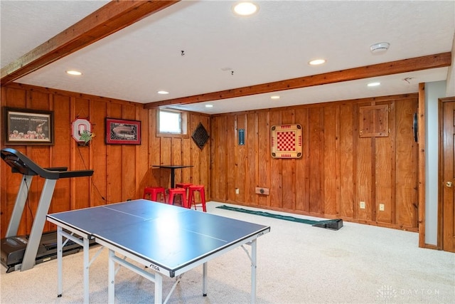 game room featuring carpet floors, beam ceiling, and wooden walls