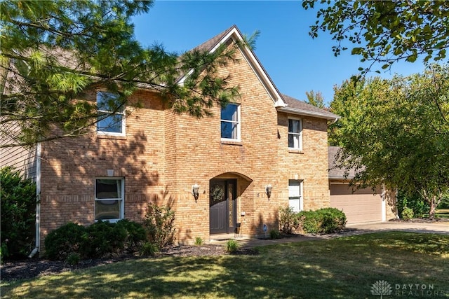 view of front of property with driveway, a front yard, and brick siding