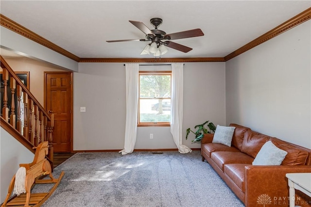 carpeted living room with ceiling fan, crown molding, baseboards, and stairs