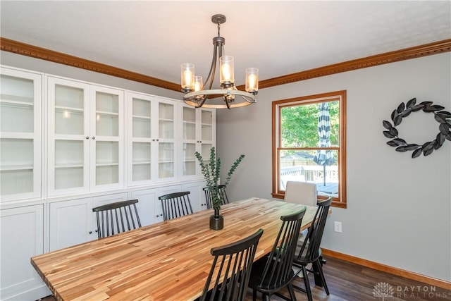 dining space featuring an inviting chandelier, crown molding, baseboards, and dark wood-type flooring