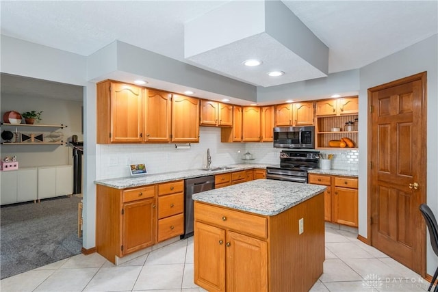 kitchen with light stone counters, tasteful backsplash, appliances with stainless steel finishes, a sink, and a kitchen island