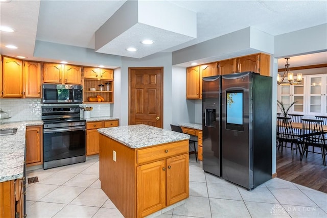 kitchen featuring stainless steel appliances, backsplash, light stone counters, and light tile patterned floors