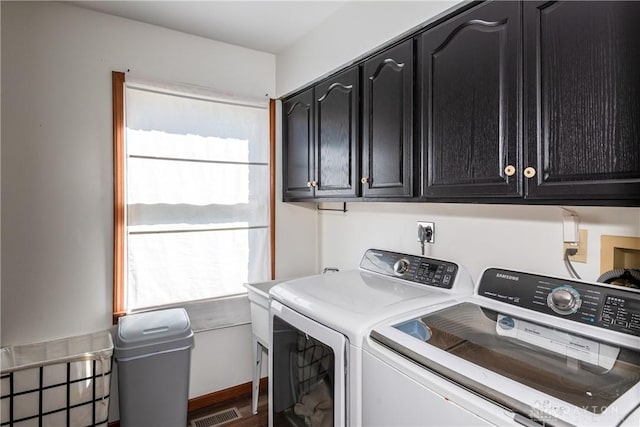 laundry area featuring cabinet space, visible vents, and separate washer and dryer