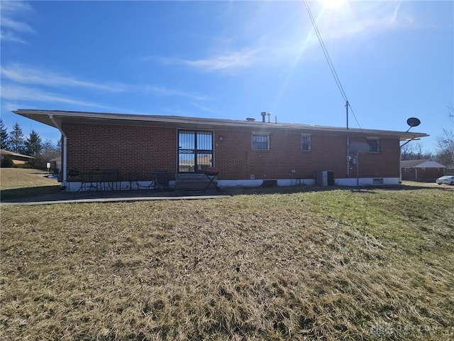 back of house with brick siding, central air condition unit, a lawn, entry steps, and crawl space