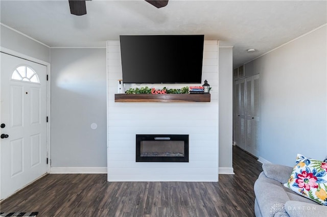 unfurnished living room with a large fireplace, wood finished floors, a ceiling fan, and baseboards