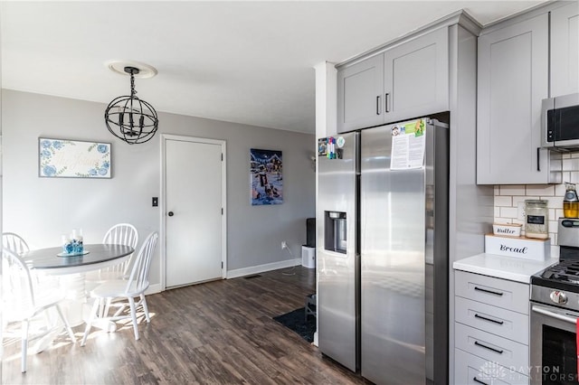 kitchen with tasteful backsplash, dark wood-style flooring, light countertops, stainless steel appliances, and gray cabinetry