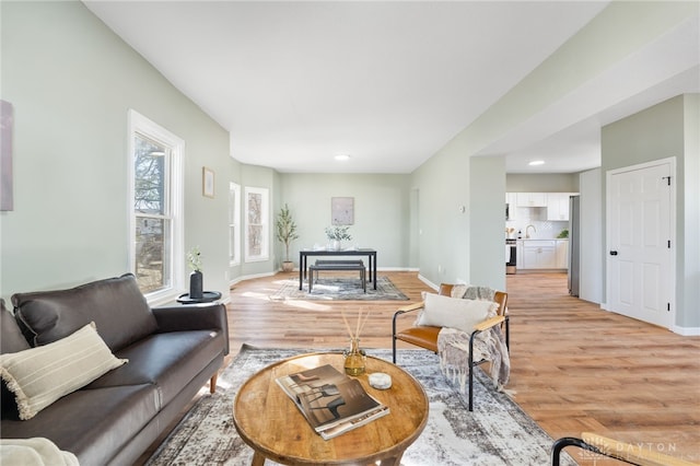 living area with baseboards and light wood-style floors