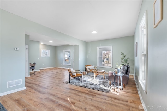 living area featuring light wood-style floors, baseboards, and visible vents