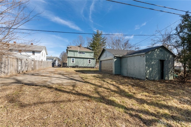 view of yard with an outbuilding, a detached garage, and fence