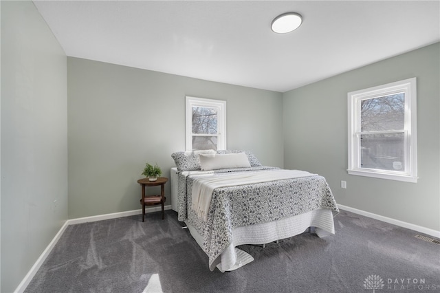 bedroom featuring dark colored carpet, visible vents, and baseboards