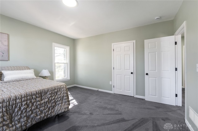 bedroom featuring dark colored carpet, visible vents, and baseboards