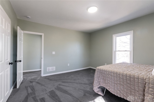 bedroom with visible vents, dark carpet, and baseboards