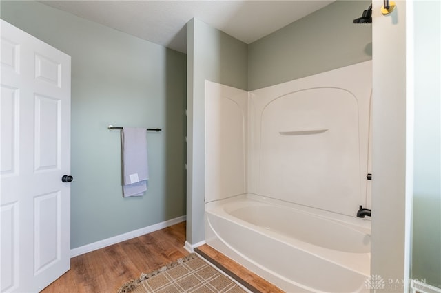 full bathroom with wood finished floors and baseboards