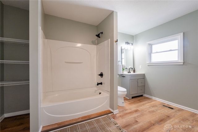 full bathroom with visible vents, toilet, wood finished floors, bathtub / shower combination, and vanity