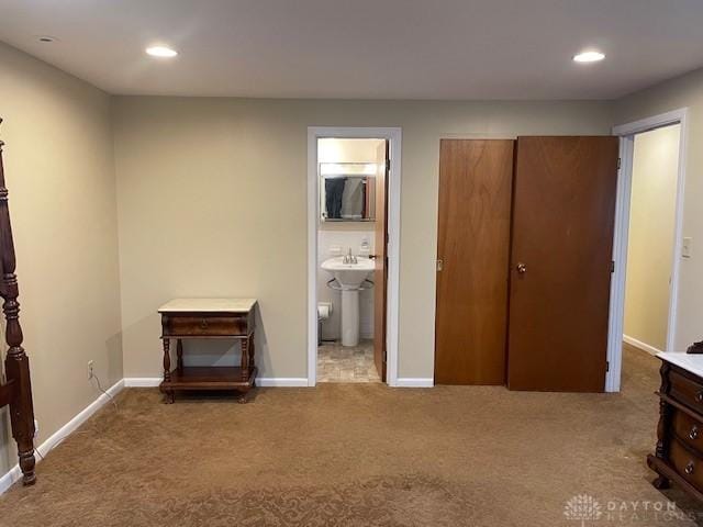 unfurnished bedroom with carpet, baseboards, a sink, and recessed lighting