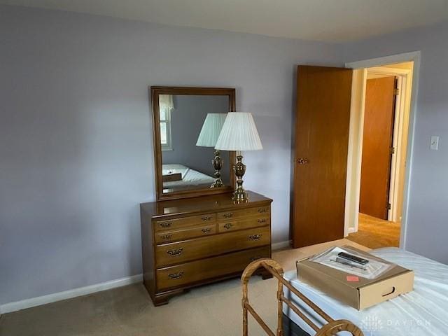 bedroom featuring light colored carpet and baseboards