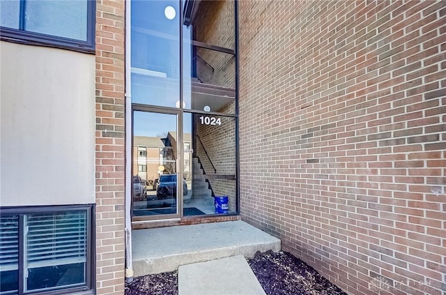 view of exterior entry featuring brick siding