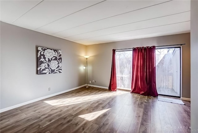 empty room with baseboards and wood finished floors