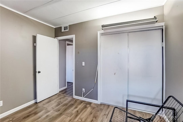 unfurnished bedroom featuring light wood-style flooring, a closet, visible vents, and baseboards