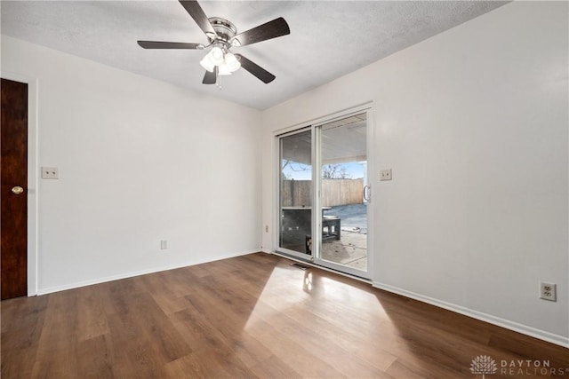 spare room with a textured ceiling, ceiling fan, wood finished floors, and baseboards