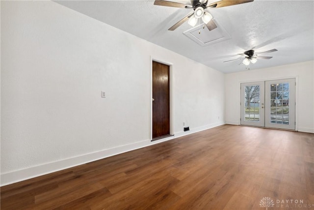 empty room with baseboards, ceiling fan, wood finished floors, a textured ceiling, and french doors