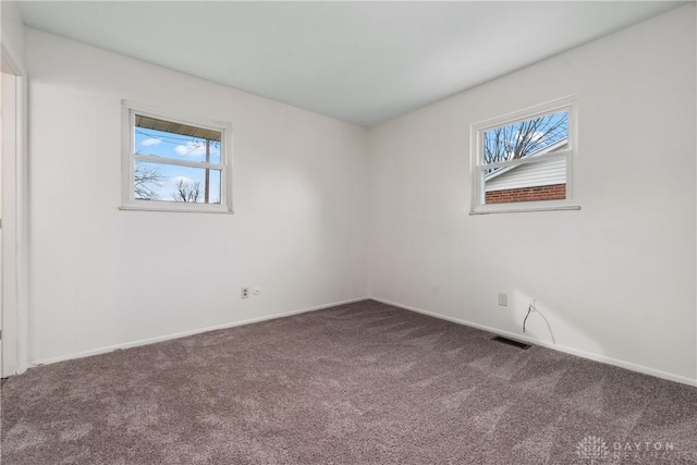 carpeted empty room with visible vents and baseboards