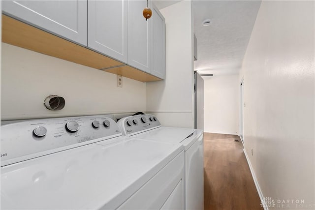 washroom with cabinet space, independent washer and dryer, baseboards, and wood finished floors