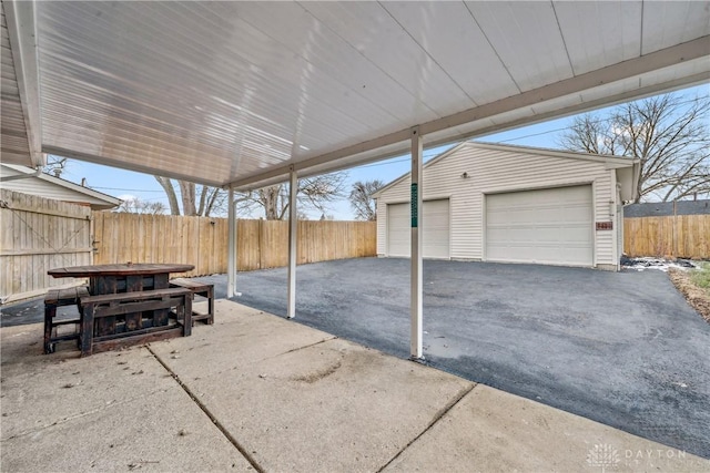 view of patio featuring an outbuilding, a detached garage, and fence