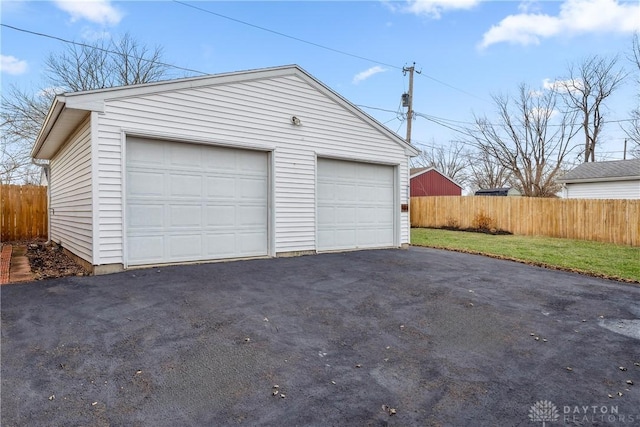 detached garage featuring fence