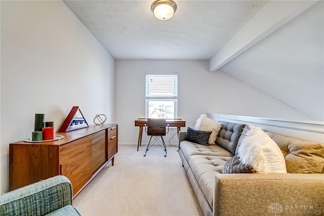 living area featuring lofted ceiling with beams, baseboards, and light colored carpet