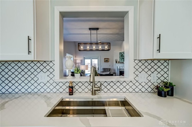 kitchen featuring light countertops, white cabinetry, and a sink