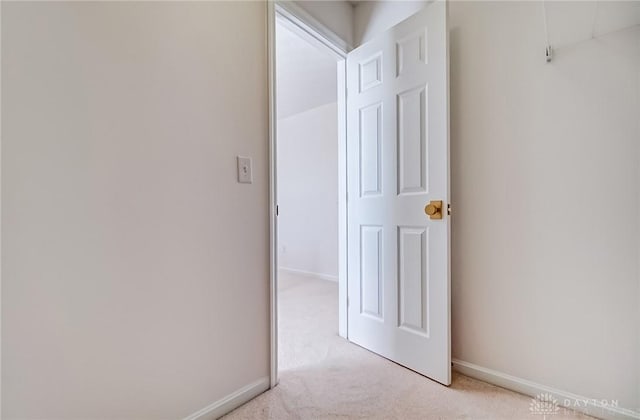 corridor with light carpet and baseboards