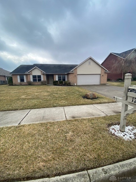 single story home with a garage, a front lawn, aphalt driveway, and brick siding