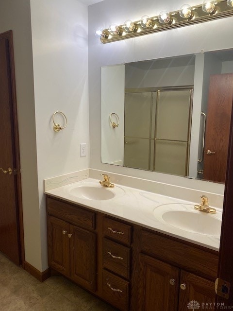 bathroom with double vanity, a sink, and a shower stall