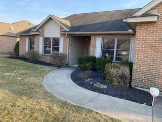 view of front of house featuring a front lawn and brick siding