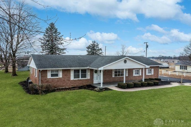 single story home featuring a front yard and brick siding