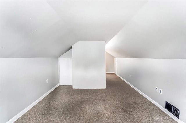 additional living space with carpet, baseboards, and vaulted ceiling