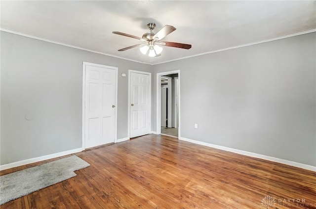 unfurnished bedroom with baseboards, crown molding, two closets, and light wood-style floors