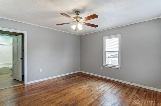 empty room featuring hardwood / wood-style flooring, ceiling fan, baseboards, and crown molding