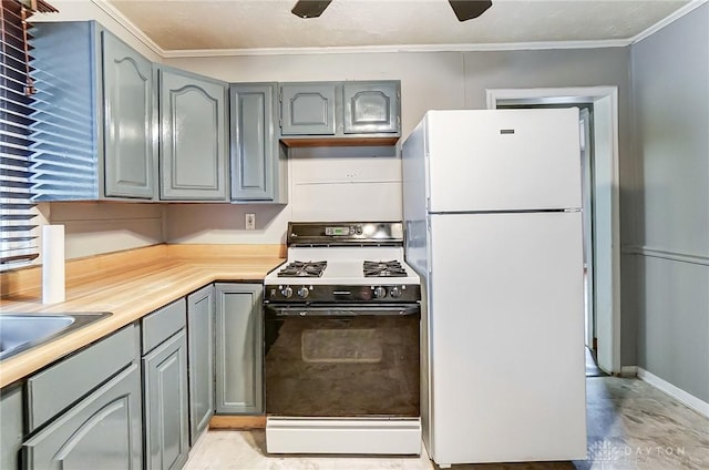 kitchen featuring range with gas cooktop, ornamental molding, freestanding refrigerator, gray cabinets, and light countertops