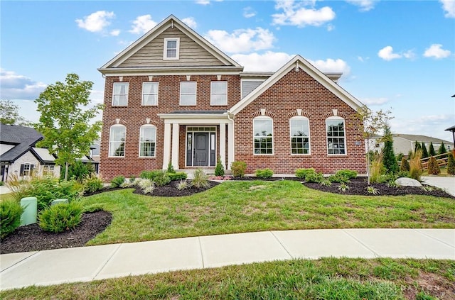 view of front of property with a front lawn and brick siding