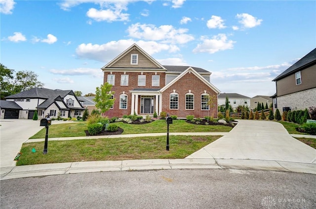 view of front of property with driveway, a front lawn, and brick siding