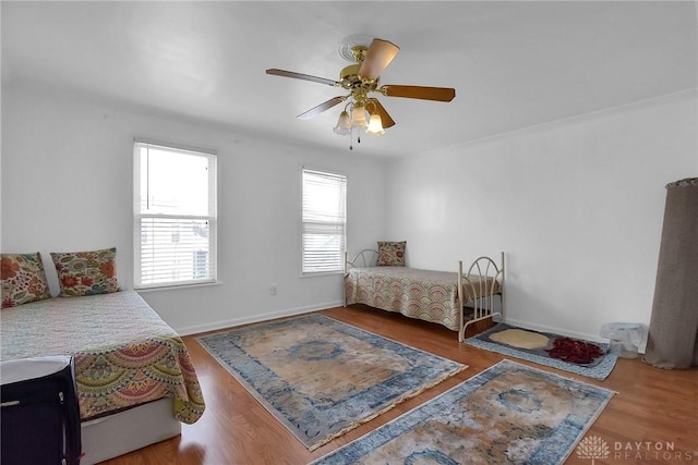 bedroom with wood finished floors, a ceiling fan, and baseboards