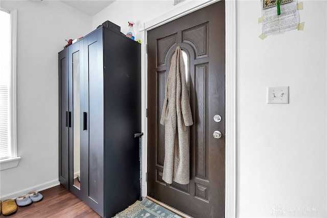 entryway with baseboards and wood finished floors